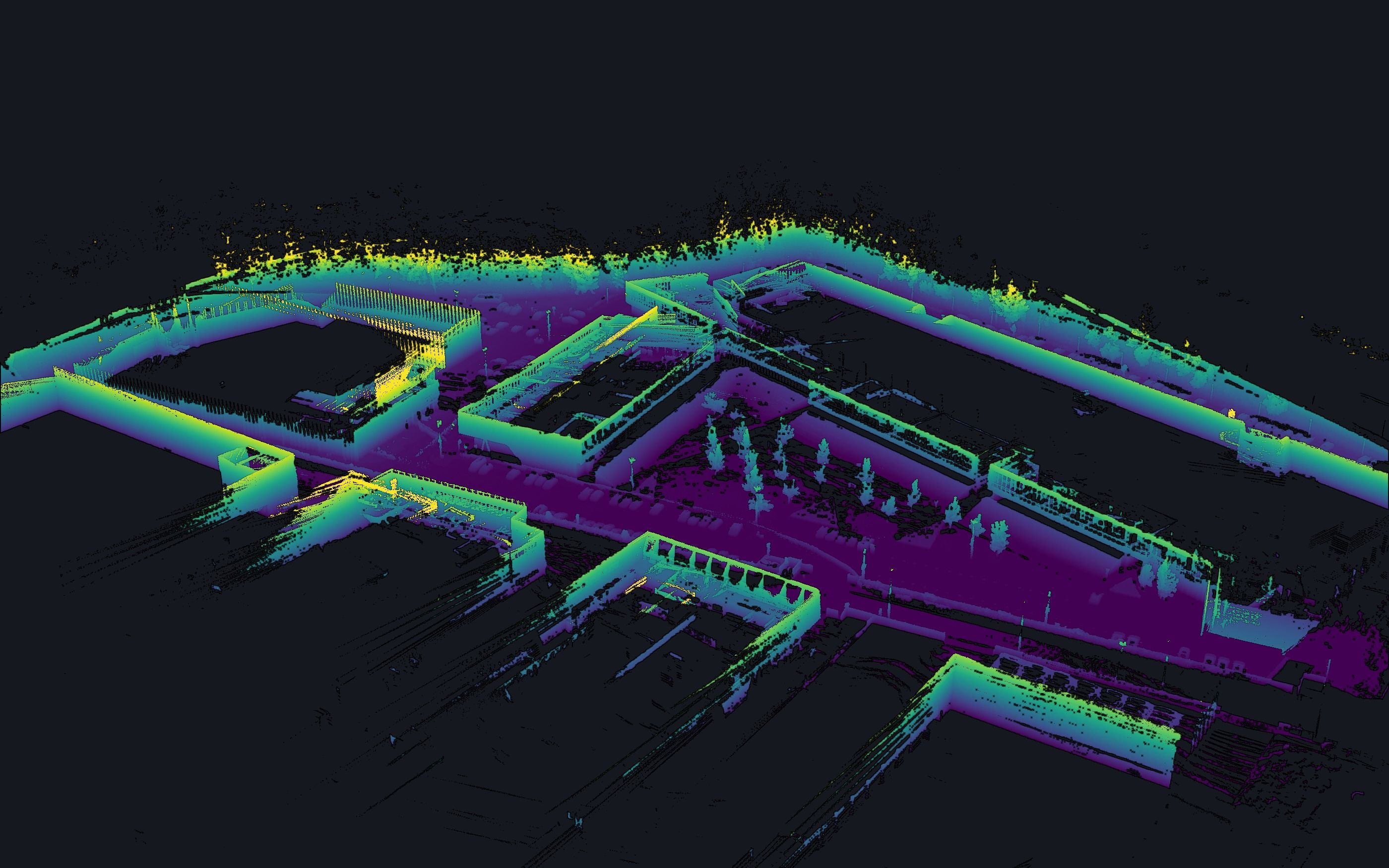 El mismo recinto en nube de puntos LiDAR real, visto desde el oeste: edificios, patio con arbolado y viales, coloreados por altura.